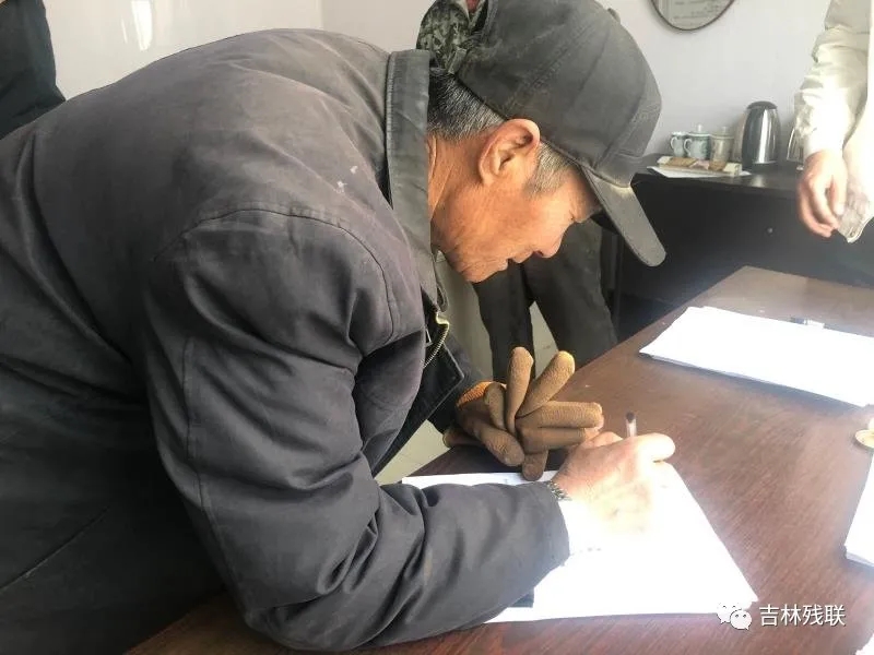 图为建档立卡残疾人与华誉电商签订合同