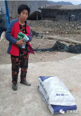 图为集安市残联为贫困残疾人送去春耕种子、化肥