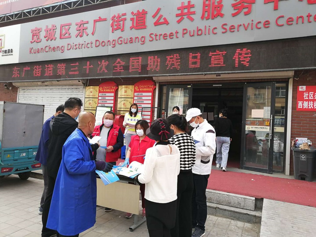 图为东广街道残联专干为参加活动的残疾人发放扶残助残手册