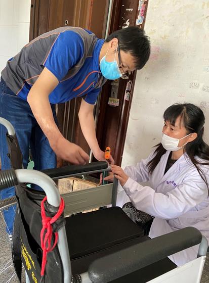图为辅具站工作人员到残疾人家为残疾人维修轮椅