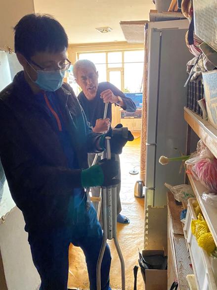 图为辅具站工作人员为残疾人维修腋拐
