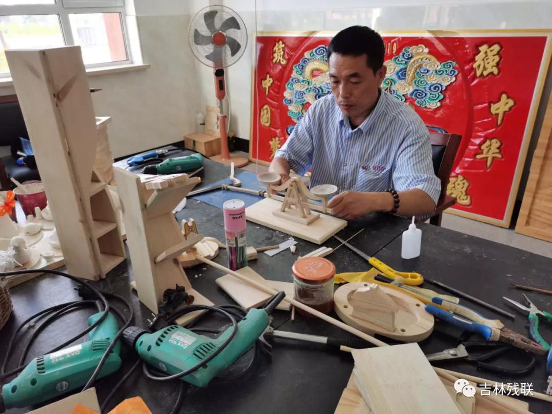 图为岳忠生在培训班里潜心琢磨设计工艺品